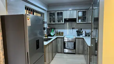 a kitchen with a stainless steel refrigerator and cabinets at ENDITO Villas in Arusha
