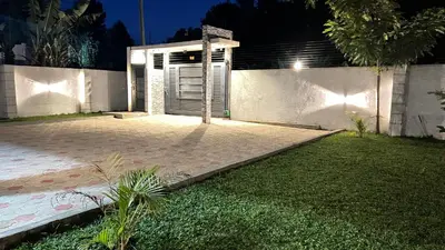 a house with a gate in a yard at night at ENDITO Villas in Arusha