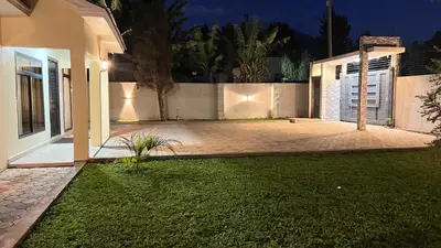 a backyard of a house at night with a driveway at ENDITO Villas in Arusha