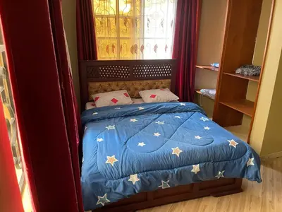 a bedroom with a bed with a blue comforter with stars at The Golden Suite Apartment in Arusha