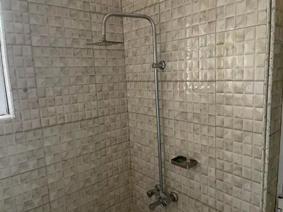 a bathroom with a shower with a glass door at The Golden Suite Apartment in Arusha