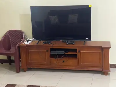 a wooden entertainment center with a large television on it at Arusha Serenity Apartment in Arusha