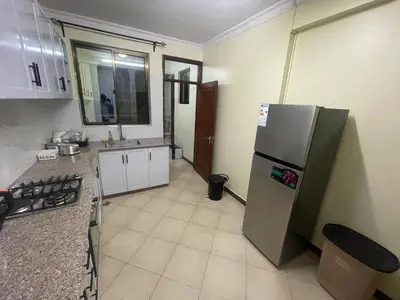 a kitchen with a stainless steel refrigerator and a sink at Arusha Serenity Apartment in Arusha