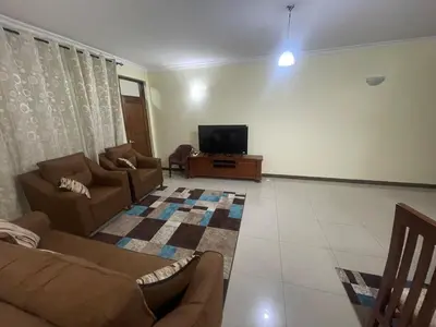 a living room with a couch and a tv at Arusha Serenity Apartment in Arusha