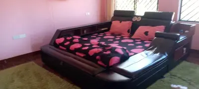 a large bed in a bedroom with a black frame at Sauda Homestay in Arusha