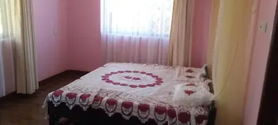 a bed with a red and white blanket on it at Sauda Homestay in Arusha