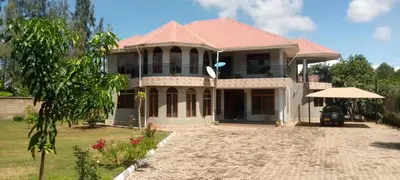 a large white house with a red roof at Sauda Homestay in Arusha