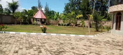 a backyard with a yard with a gazebo at Sauda Homestay in Arusha
