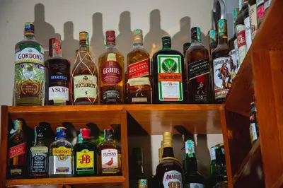 a bunch of bottles of alcohol sitting on a shelf at Kili Spring Hotel in Arusha