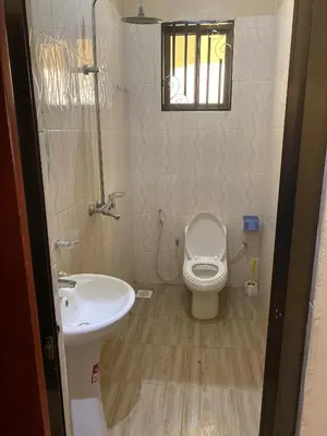 a bathroom with a toilet and a sink at Kili Spring Hotel in Arusha