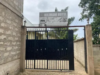 a gate to a hotel with a sign behind it at Kili Spring Hotel in Arusha
