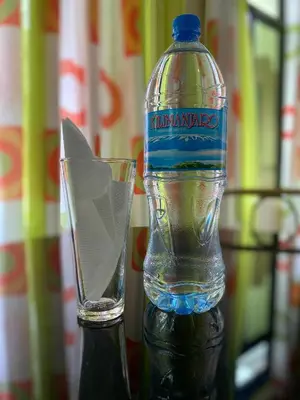 a bottle of water and a glass on a table at Kili Spring Hotel in Arusha