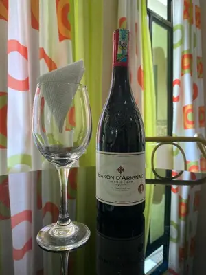 a bottle of wine next to a wine glass at Kili Spring Hotel in Arusha