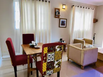 a living room with a dining room table and chairs at The Dawn cottage in Moshi