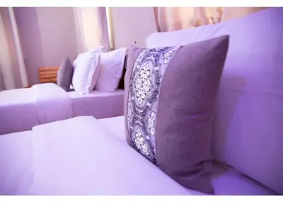 a purple pillow sitting on a couch in a room at The Dawn cottage in Moshi