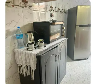 a kitchen with a microwave and a counter with cups at Samirehousea in Msaranga