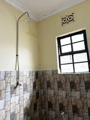 a bathroom with a shower and a window at 'La Maison' 2 bedroom house in Arusha in Arusha