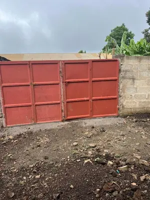 a red gate in front of a wall at 'La Maison' 2 bedroom house in Arusha in Arusha