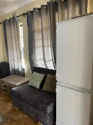 a living room with a couch and a refrigerator at 'La Maison' 2 bedroom house in Arusha in Arusha