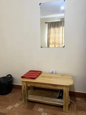 a mirror and a wooden bench in a room at 'La Maison' 2 bedroom house in Arusha in Arusha