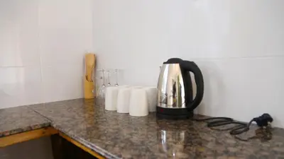 a tea kettle on a counter with paper towels at Velam Home Stay in Arusha