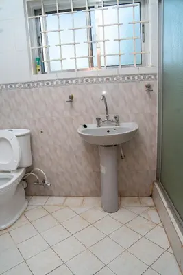 a bathroom with a sink and a toilet at Kwetu Hostel in Arusha