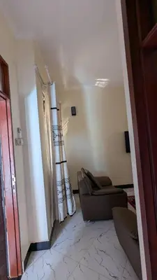 a living room with a couch and a chair at Homeland Apartments in Arusha