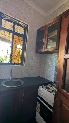 a kitchen with a sink and a stove and a window at Homeland Apartments in Arusha