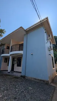 a white building with a large door in front of it at Homeland Apartments in Arusha