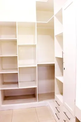a walk in closet with white shelves at Asante Karibu House in Arusha
