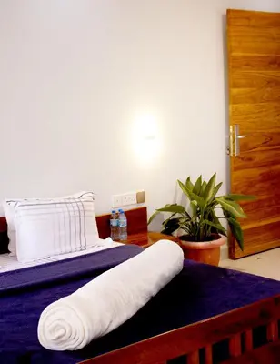 a bed with a white towel on top of it at Asante Karibu House in Arusha