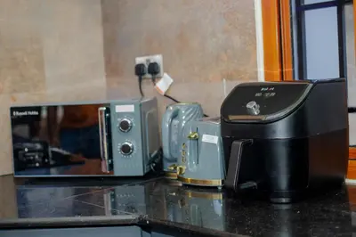a kitchen counter with a microwave and a toaster at Abasimba House Arusha in Themi