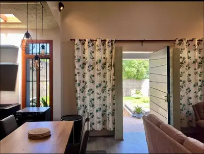 a dining room with a table and a sliding glass door at Abasimba House Arusha in Themi
