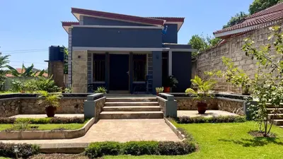 a house with a blue facade and a yard at Abasimba House Arusha in Themi