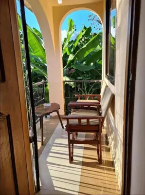 a porch with two chairs and a table on it at Villa Jane in Arusha in Arusha