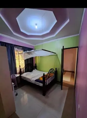 a bedroom with a bed and a ceiling with a chandelier at Villa Jane in Arusha in Arusha