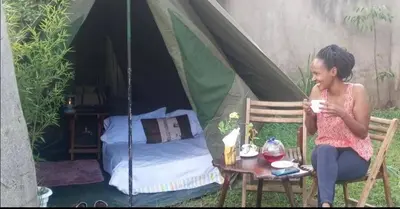a woman sitting in a chair in front of a tent at Villa Jane in Arusha in Arusha