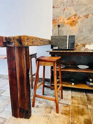 a wooden desk with a stool next to a piano at City Retreat Studio X in Arusha