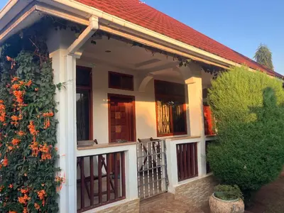 a house with a balcony with a gate at Barazani Garden House in Moshi