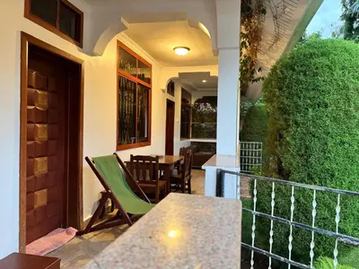 a balcony with a table and chairs on a house at Barazani Garden House in Moshi