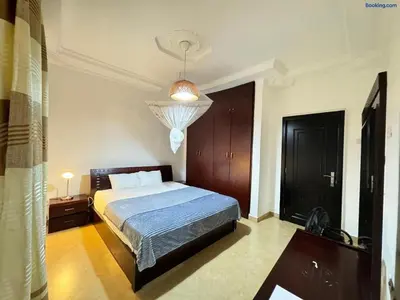 a bedroom with a bed and a chandelier at Barazani Garden House in Moshi