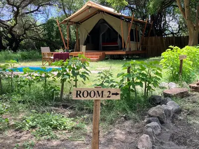a sign in front of a tent in a yard at Keremasi Camp Lake Natron in Mtowabaga