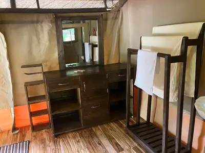 a bedroom with a desk and a mirror and a bed at Keremasi Camp Lake Natron in Mtowabaga