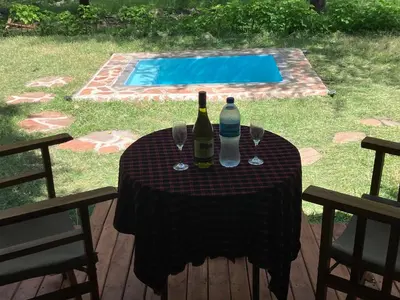 a table with two bottles of wine and two glasses at Keremasi Camp Lake Natron in Mtowabaga