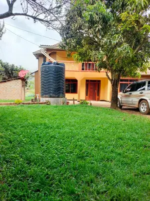 a house with a large tire in front of a yard at Bright Michelle Homestay in Lushoto