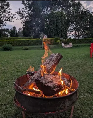 a fire pit with a log in it at Jibambe campsite in Moshi