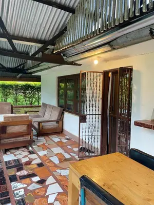a room with a patio with a couch and a table at Jibambe campsite in Moshi