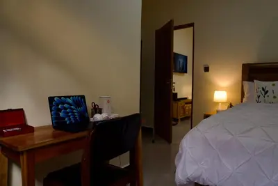 a bedroom with a desk with a bed and a desk sidx sidx sidx at Nyumbani Nyumbani in Arusha