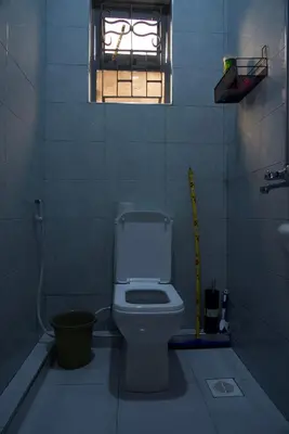 a small bathroom with a toilet and a window at Nyumbani Nyumbani in Arusha