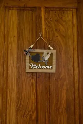 a welcome sign hanging on a wooden door at Nyumbani Nyumbani in Arusha